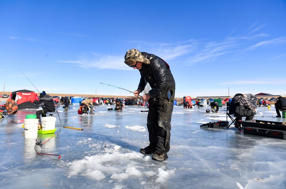 Bill Hartman drops a line to begin the 12th annual Ice Fish Fest on Saturday, January 29, 2022 at Catfish Bay in Sioux Falls.