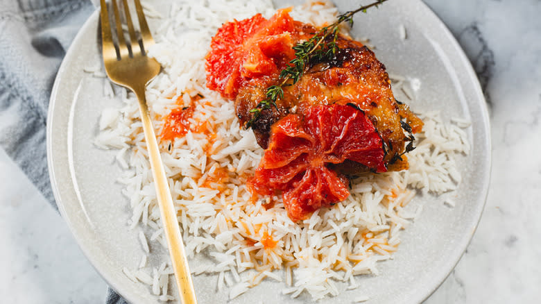 Chicken in plate over rice with grapefruit and thyme