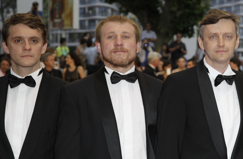 From left, actors Vlad Abashin, Vladimir Svirski and director Sergei Loznitsa arrive for the screening of In The Fog at the 65th international film festival, in Cannes, southern France, Friday, May 25, 2012. (AP Photo/Francois Mori)