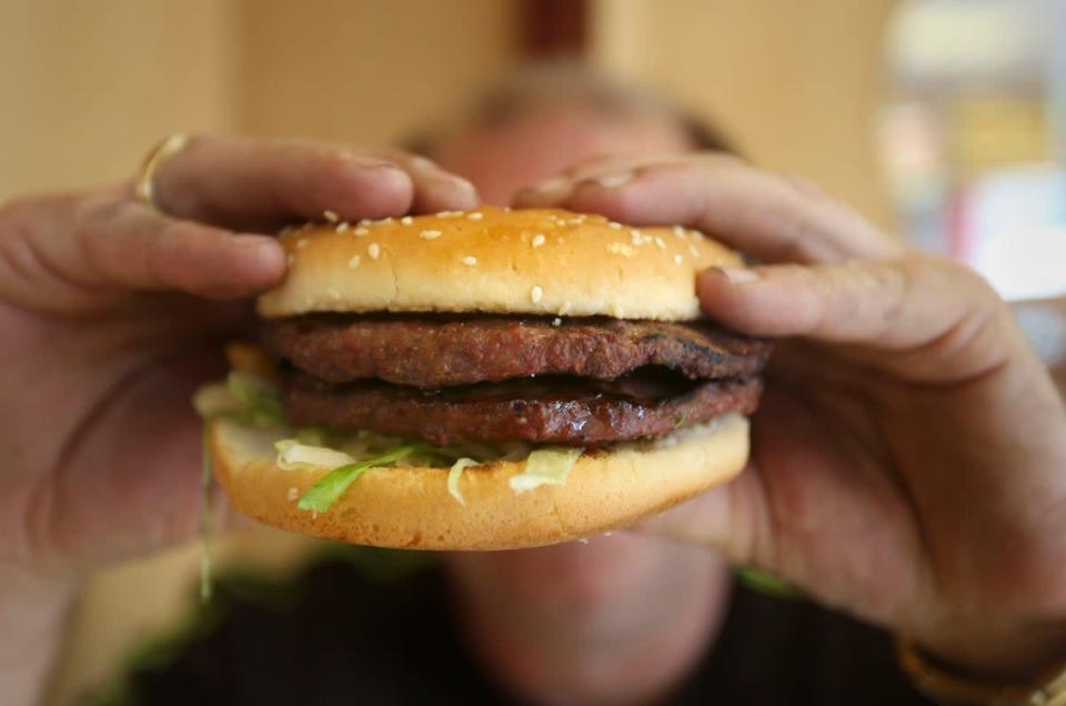 Man holding a burger (PA) (PA Archive)