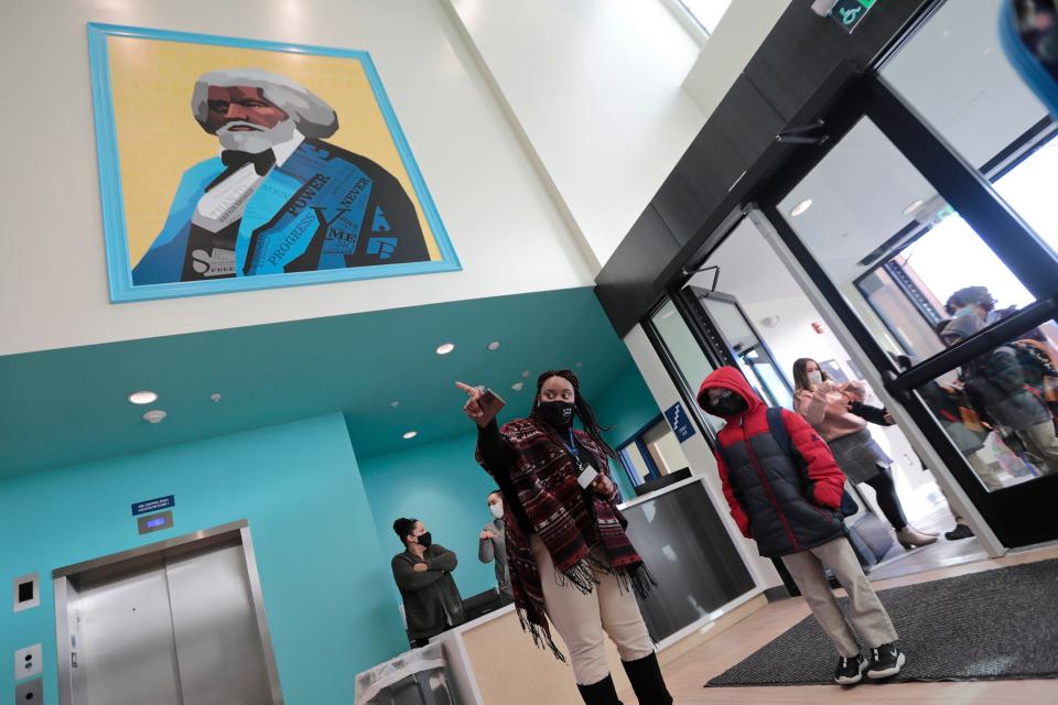 A painting of Frederick Douglass hangs on the wall as third grade teacher, Roshonda Ndebumadu direct students on the first day of school at the new Alma del Mar Frederick Douglass campus on Church Street in New Bedford.