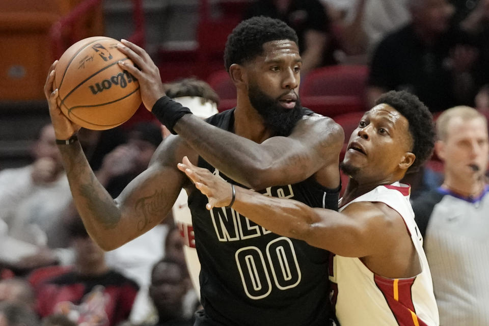 Brooklyn Nets forward Royce O'Neale (00) looks for an open teammate past Miami Heat guard Kyle Lowry during the first half of an NBA basketball game, Wednesday, Nov. 1, 2023, in Miami. (AP Photo/Wilfredo Lee)