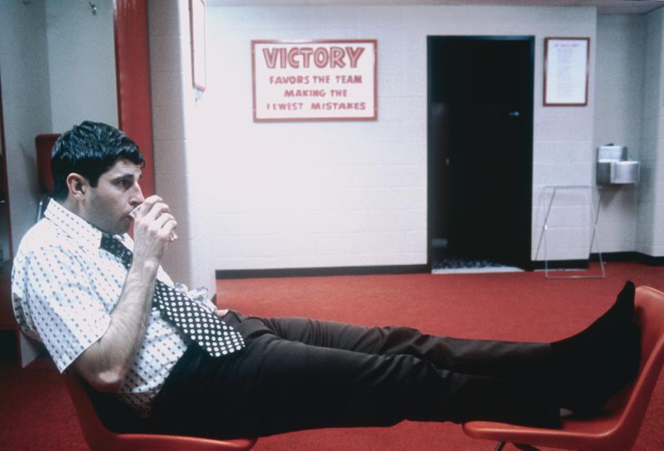 Bob Knight sipping drink out of cup with legs up on chair