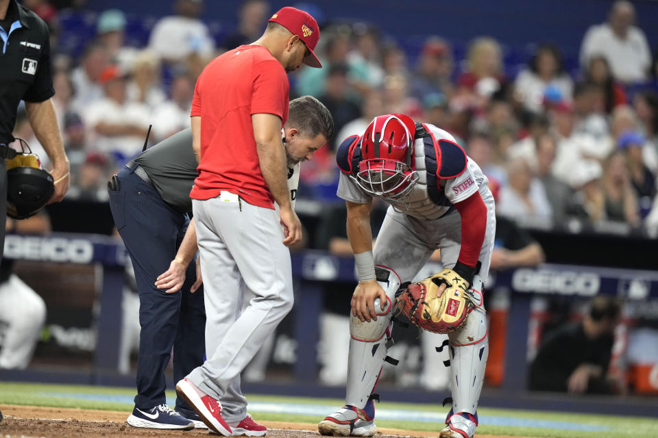 St. Louis Cardinals manager Oliver Marmol, center, stands with catcher Andrew Knizner after an injury during the fourth inning of a baseball game against the Miami Marlins, Tuesday, July 4, 2023, in Miami. (AP Photo/Lynne Sladky)