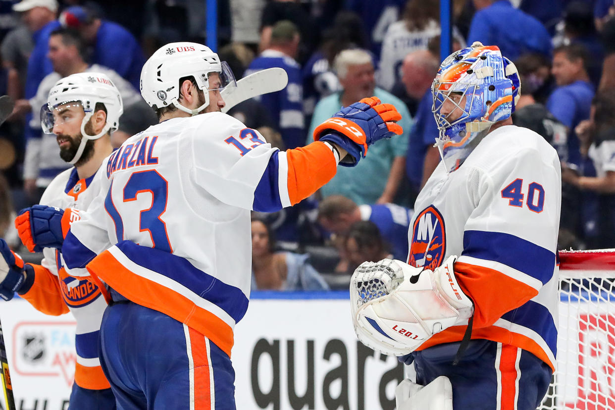 TAMPA, FLORIDA - JUNE 13:  Mathew Barzal #13 and Semyon Varlamov #40 of the New York Islanders celebrate their teams 2-1 victory against the Tampa Bay Lightning in Game One of the Stanley Cup Semifinals during the 2021 Stanley Cup Playoffs at Amalie Arena on June 13, 2021 in Tampa, Florida. (Photo by Mike Carlson/Getty Images)