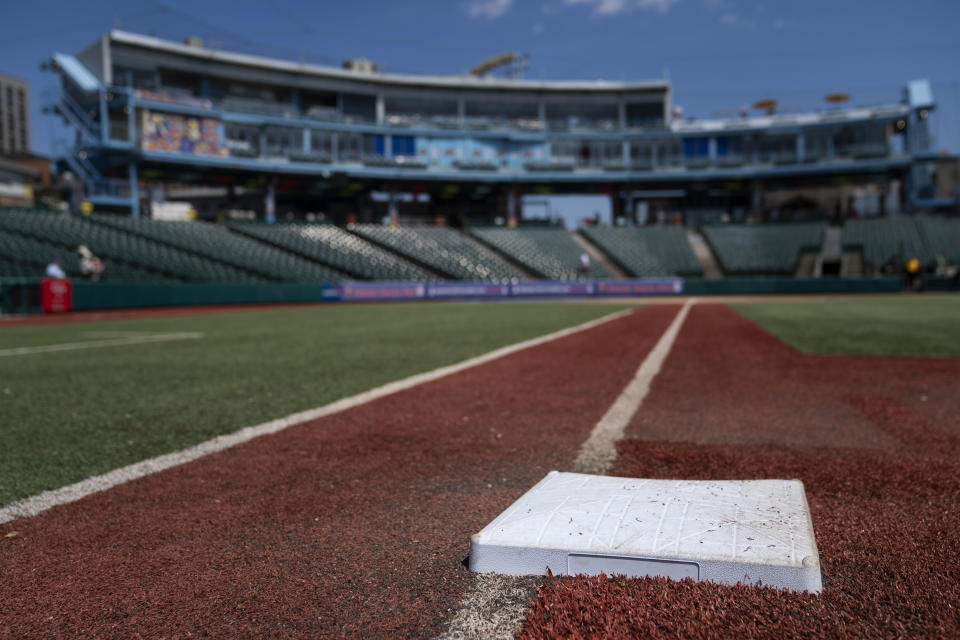 Larger bases are installed on the infield before a minor league baseball game between the Brooklyn Cyclones and Greensboro Grasshoppers, Wednesday, July 13, 2022, in the Coney Island neighborhood of the Brooklyn borough of New York. Major League Baseball is considering a pitch clock for next year along with shift limits, larger bases and restrictions on pickoff attempts. (AP Photo/John Minchillo)