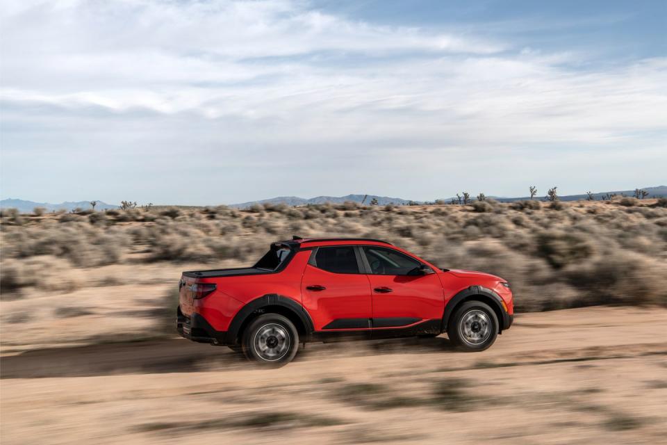 a red car parked on a dirt road