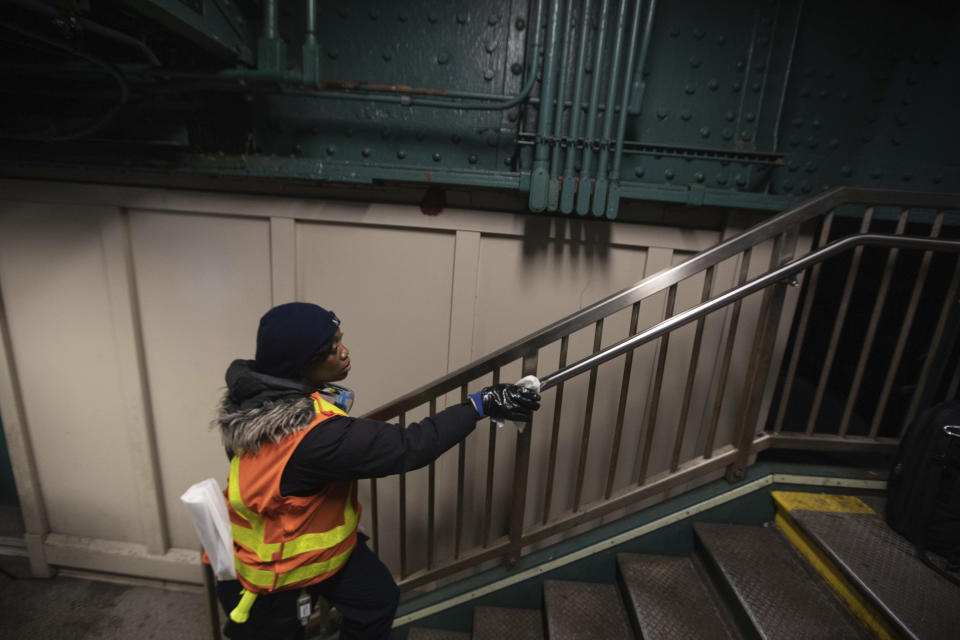 Metropolitan Transportation Authority worker S. Williams works to sanitize surfaces at the Avenue X subway station, Tuesday, March 3, 2020, in the Brooklyn borough of New York. The MTA is stepping up efforts to sanitize cars and stations as fears mount over the coronavirus. (AP Photo/Kevin Hagen)