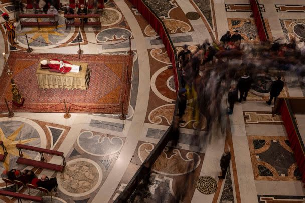 PHOTO: A stream of mourners approach the body of late Pope Emeritus Benedict XVI lying out in state inside St. Peter's Basilica at The Vatican where thousands went to pay their homage, Jan. 3, 2023. (Domenico Stinellis/AP)