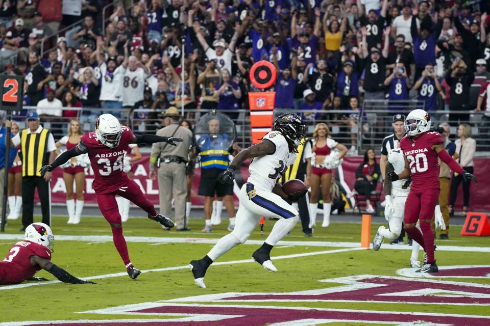 Baltimore Ravens running back Gus Edwards (35) enters the endzone for a touchdown past Arizona Cardinals safety Jalen Thompson (34) during the second half of an NFL football game Sunday, Oct. 29, 2023, in Glendale, Ariz. (AP Photo/Ross D. Franklin)