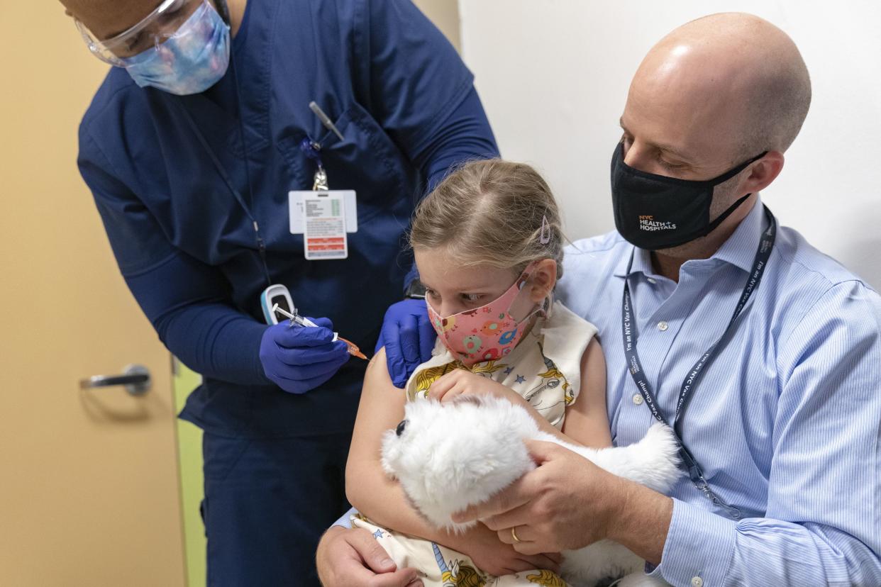 Registered nurse Brett Lastra inoculates Ella Siegler, 5, with the first dose of the Pfizer-BioNTech COVID-19 vaccine at NYC Health + Hospitals Harlem Hospital in Manhattan, New York.