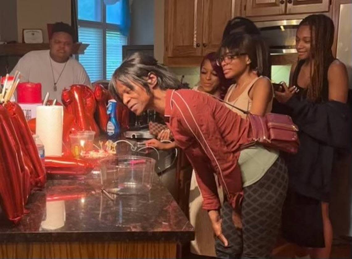 Connie Mae Gooden blows out candles on her birthday cake, surrounded by family.