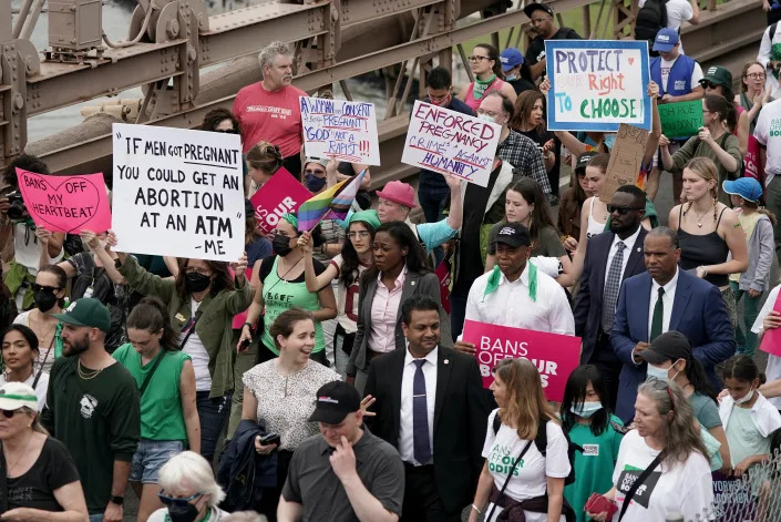 New York City Mayor Eric Adams, wearing a black cap and carrying a pink sign, marches with abortion-rights activists on May 14, 2022, in New York.