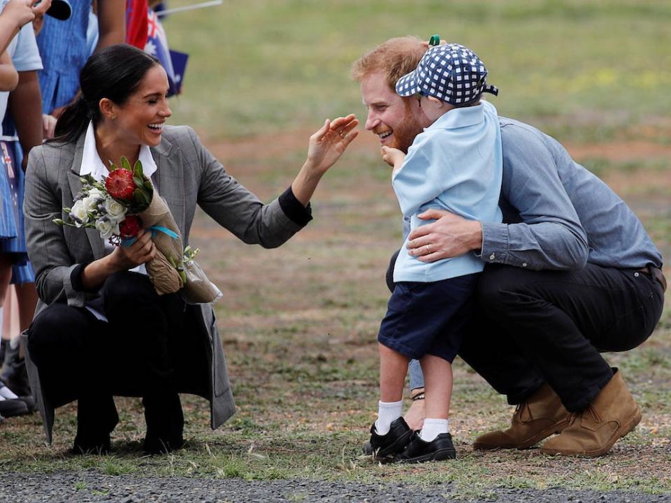 A young boy rubs Prince Harry's beard in Australia