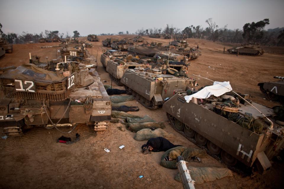 ISRAEL/GAZA BORDER, ISRAEL- NOVEMBER 19: (ISRAEL OUT) Israeli soldiers sleep next to their tanks in a deployment area on November 19, 2012 on Israel's border with the Gaza Strip. The death toll has risen to at least 85 killed in the air strikes, according to hospital officials, on day six since the launch of operation 'Pillar of Defence.' (Photo by Uriel Sinai/Getty Images)