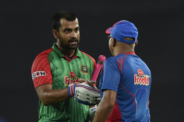 Bangladesh cricketer Tamim Iqbal (L) shakes hands with coach Upul Chandika Hathurusingha after winning the second One Day International cricket match between Bangladesh and Pakistan in Dhaka on April 19, 2015