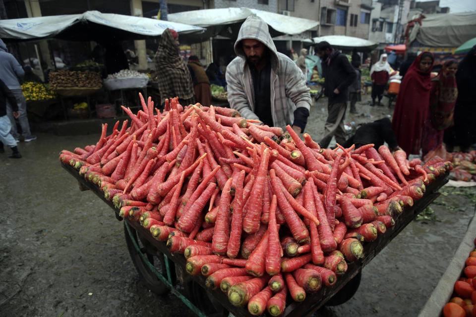 FILE - A produce vendor arranges carrots as he waits for customers at a market in Islamabad, Pakistan, on Jan. 22, 2022. Growing numbers of people in Asia lack enough food to eat as food insecurity rises with higher prices and worsening poverty, according to a report by the Food and Agricultural Organization and other UN agencies released Tuesday, Jan. 24, 2023. (AP Photo/Rahmat Gul, File)