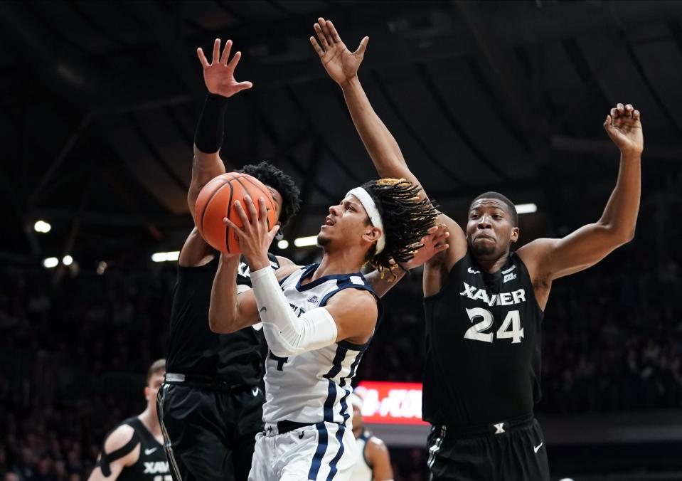 Mar 6, 2024; Indianapolis, Indiana, USA; Butler Bulldogs guard DJ Davis (4) goes to the basket against Xavier Musketeers guard Dayvion McKnight (20) and Xavier Musketeers forward Abou Ousmane (24) during the first half at Hinkle Fieldhouse.