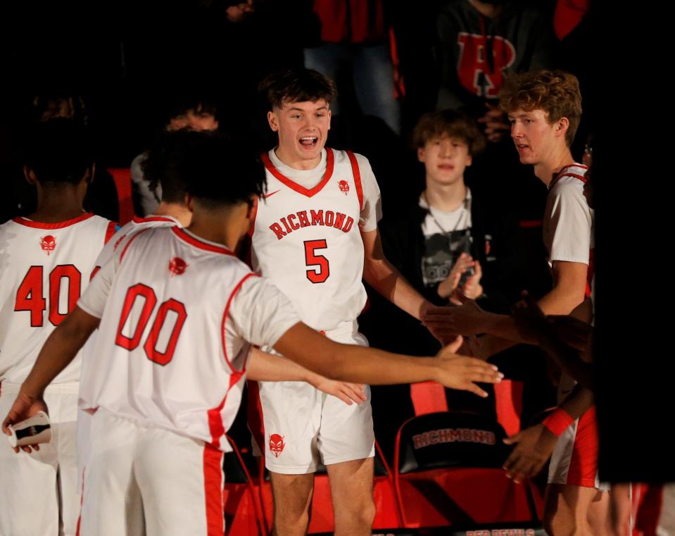 Richmond junior Ryder Cate high-fives his teammates as the starting five is announced before a game against Connersville Dec. 17, 2022.