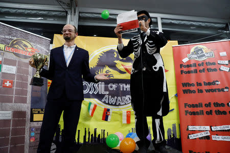 An activist acting as a representative of Poland receives the 'Colossal Fossil' award, offered by environmental activists from the The Climate Action Network (CAN), which is given to the country deemed to have done its best to block progress in the negotiations or in the implementation of the Paris Agreement, during the COP24 UN Climate Change Conference 2018 in Katowice, Poland December 13, 2018. REUTERS/Kacper Pempel