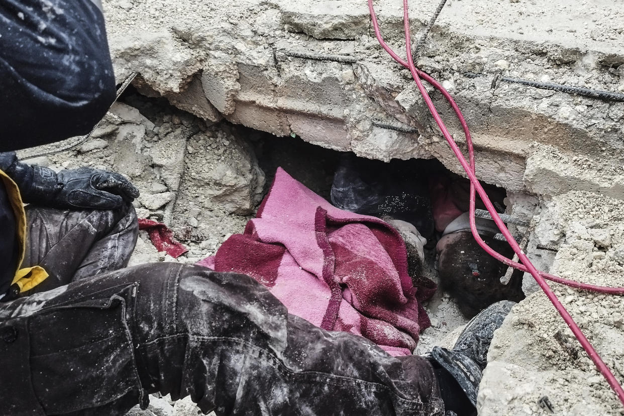 Syrian civil defense workers search for people under the rubble of a destroyed building in Afrin, Syria.