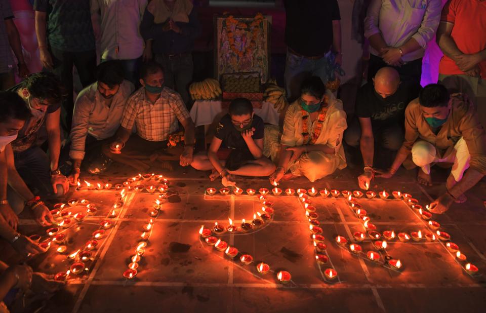 Hindu devotees light oil lamps forming the words "Shri Ram" as they celebrate on the eve of groundbreaking ceremony of the proposed Ram Temple, in Ayodhya, at the Ram Temple in Amritsar on August 4, 2020. - India's Prime Minister Narendra Modi will lay the foundation stone for a grand Hindu temple in a highly anticipated ceremony at a holy site that was bitterly contested by Muslims, officials said. (Photo by NARINDER NANU / AFP) (Photo by NARINDER NANU/AFP via Getty Images)