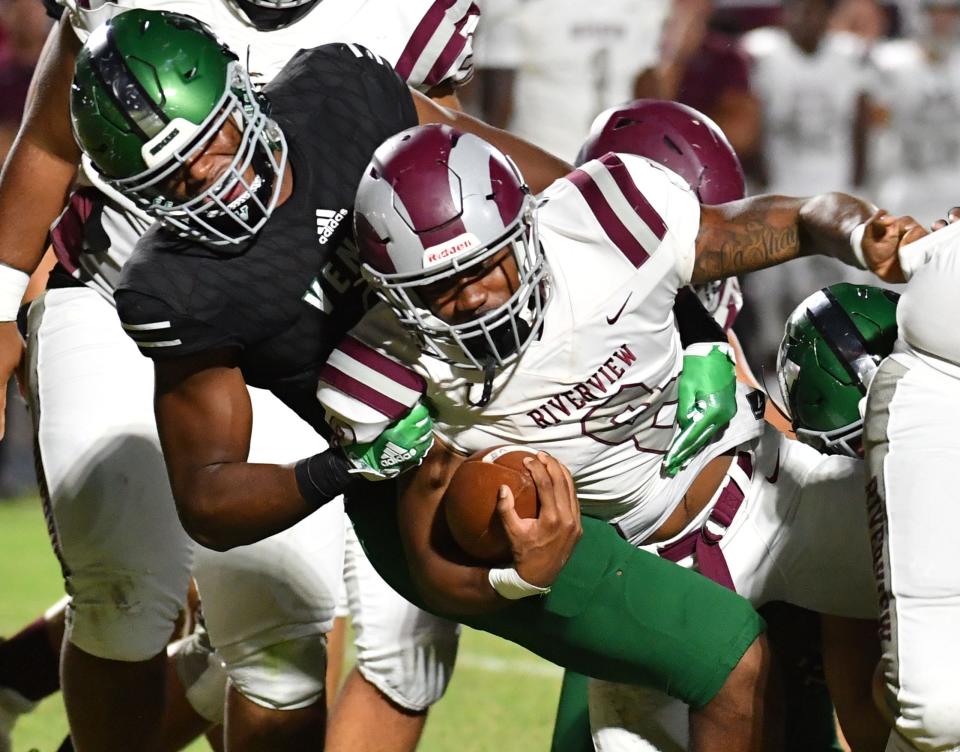 Riverview running back Jayden Birch (#8) is wrapped up by Venice defender Damon Wilson (#11). Venice High hosted Riverview High Friday night for the Class 8A-District 12 championship.  Venice defeated Riverview 42-7. 