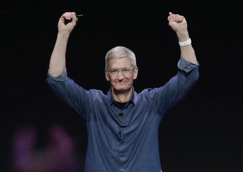 Tim Cook with his arms raised