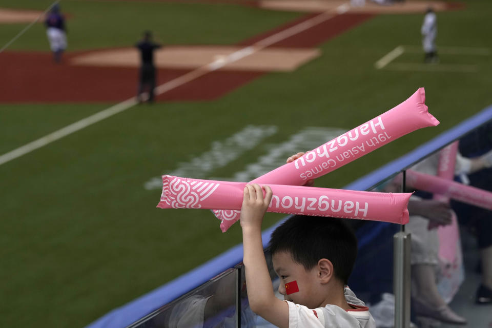 A child with Chinese national flag decal on his cheek attend a stage group round B Baseball Men game between Taiwan and Hong Kong for the 19th Asian Games in Hangzhou, China on Tuesday, Oct. 3, 2023. At the Asian Games China has been going out of its way to be welcoming to the Taiwanese athletes, as it pursues a two-pronged strategy with the goal of taking over the island, which involves both wooing its people while threatening it militarily. (AP Photo/Ng Han Guan)