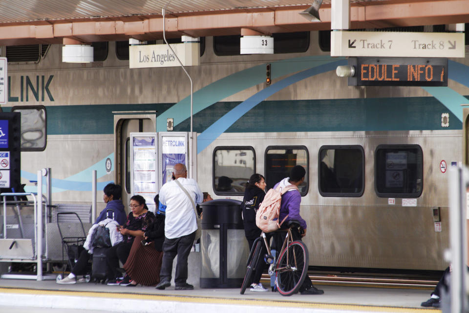 Passengers wait for a Metrolink train at Union Station in Downtown Los Angeles on Monday, Nov. 13, 2023. Los Angeles drivers are being tested in their first commute since a weekend fire that closed a major elevated interstate near downtown. Commuters were urged to work from home or take public transportation into downtown Los Angeles. (AP Photo/Richard Vogel)