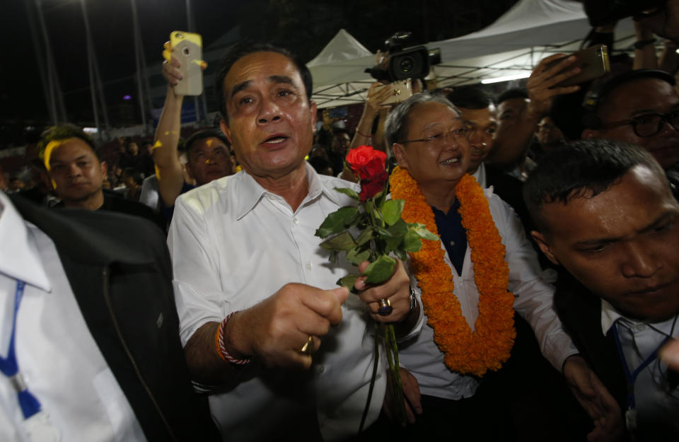 Thai Prime Minister Prayuth Chan-ocha of the Palang Pracharat Party receives flowers from supporters during an election campaign rally in Bangkok, Thailand, Friday, March 22, 2019. The political movement that has won every Thai election in nearly two decades is facing its biggest test yet: Squaring off against the allies of the military junta that removed it from power and rewrote the electoral rules with the goal of putting an end to those victories. (AP Photo/Sakchai Lalit)