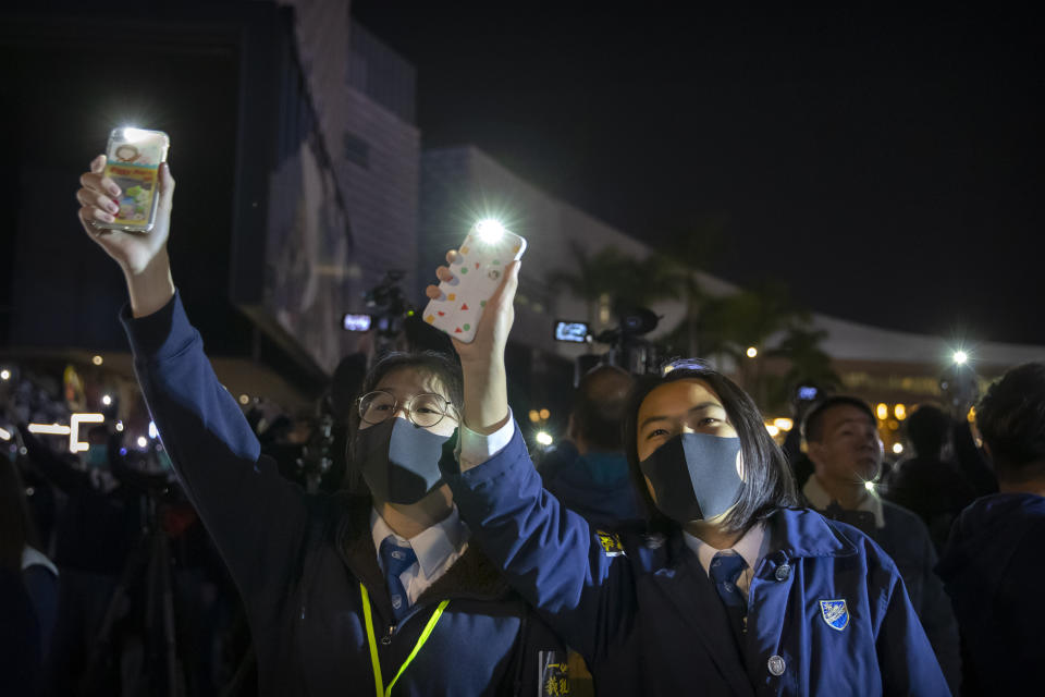 Protesters wave their smartphones as they sing "Glory to Hong Kong" during a rally for secondary school students near the Hong Kong Museum of Art in Hong Kong, Friday, Dec. 13, 2019. Protesters in Hong Kong wrote hundreds of Christmas cards on Thursday for people jailed in the city's pro-democracy movement, promising they won't be forgotten as they face spending the festive season behind bars. (AP Photo/Mark Schiefelbein)