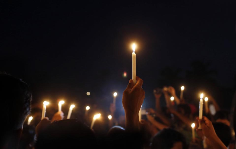 Bangladeshi relatives of victims of last year’s Rana Plaza building collapse, along with activists hold candles during a gathering on the eve of the tragedy, the worst in the history of the garment industry, in Savar, near Dhaka, Bangladesh, Wednesday, April 23, 2014. More than 1,100 people were killed when the illegally constructed, 8-storey building collapsed on April 24, 2013, in a heap along with thousands of workers in the five garment factories in the building. (AP Photo/A.M. Ahad)