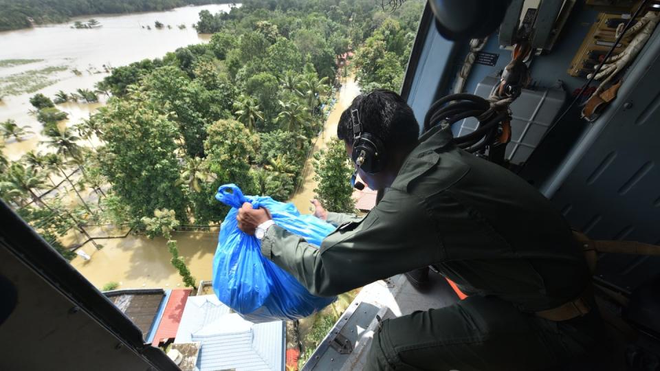 Ein Soldat verteilt Hilfsgüter aus einem Helikopter. Der südindische Bundesstaat Kerala ist nach Regierungsangaben von der verheerendsten Flut der letzten 100 Jahre getroffen worden. Foto: AP