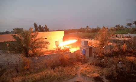 Shi'ite fighters forces launch a rocket towards Islamic State militants on the outskirts Falluja, Iraq, May 23, 2016. REUTERS/Stringer