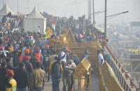 NEW DELHI, INDIA - JANUARY 26: Demonstrators removing police barricades while heading into the capital during a tractor rally on Republic Day, at Ghazipur on January 26, 2021 in New Delhi, India. Major scenes of chaos and mayhem at Delhi borders as groups of farmers allegedly broke barricades and police check posts and entered the national capital before permitted timings. Police used tear gas at Delhi's Mukarba Chowk to bring the groups under control. Clashes were also reported at ITO, Akshardham. Several rounds of talks between the government and protesting farmers have failed to resolve the impasse over the three farm laws. The kisan bodies, which have been protesting in the national capital for almost two months, demanding the repeal of three contentious farm laws have remained firm on their decision to hold a tractor rally on the occasion of Republic Day. (Photo by Sakib Ali/Hindustan Times via Getty Images)