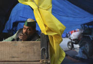 An Indian Farmer sits in his tractor trailer as he with others block a highway leading to Delhi in protest against new farm laws, at Delhi-Uttar Pradesh border, India, Friday, Jan. 22, 2021. Talks between protesting farmers’ leaders and the government ended abruptly in a stalemate on Friday with the agriculture minister saying he has nothing more to offer than suspending contentious agricultural laws for 18 months. The farmers’ organizations in a statement on Thursday said they can’t accept anything except the repeal of the three new laws. (AP Photo/Manish Swarup)