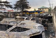 Burnt vehicles are pictured at a damaged police station in Lagos