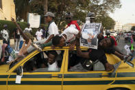 Supporters of the Gambian President Adama Barrow celebrate the partial results that give the lead to their candidate during the counting ballots in Gambia's presidential election, in Banjul, Gambia, Sunday, Dec. 5, 2021. Election officials in the West African nation of Gambia have started counting marble votes after polls closed for the first presidential election in decades that does not include former dictator Yahya Jammeh as a candidate. (AP Photo/Leo Correa)