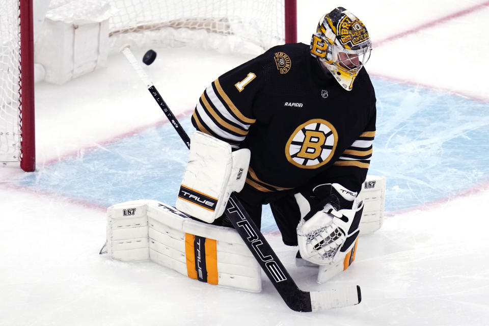 Boston Bruins goaltender Jeremy Swayman (1) drops to the ice as the puck bounces in the net after a goal by Calgary Flames center Jonathan Huberdeau during the third period of an NHL hockey game, Tuesday, Feb. 6, 2024, in Boston. (AP Photo/Charles Krupa)