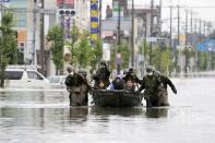 Local residents are rescued by Japan Self-Defense Force soldiers using by a boat on a flooded road caused by heavy rain in Omuta, Japan