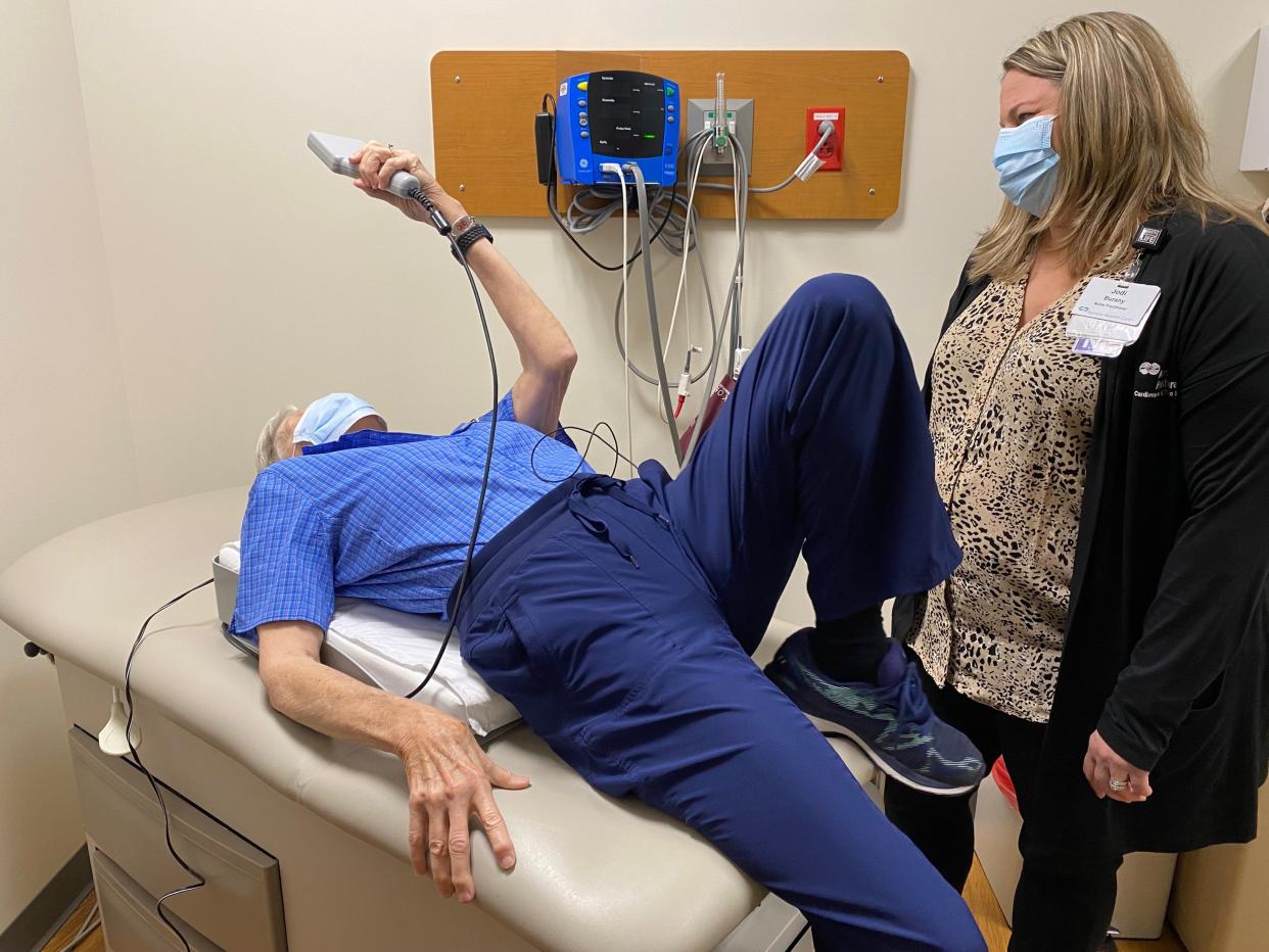 Mary Korte demonstrates how she lies on the CardioMEMS pillow to beam the implant's readings to her medical team. She can do so from anywhere she has access to cell service or Wi-Fi.