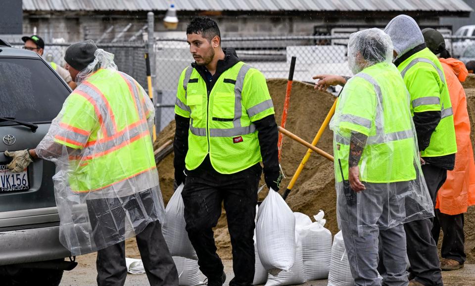 Visalia City Council Member Emmanuel Soto works with a Solid Waste crew Tuesday, March 14, 2023 to fill and distribute sandbags on Cain Street, between Goshen and Main Street. Officials estimated 20,000 had been issued through Tuesday.