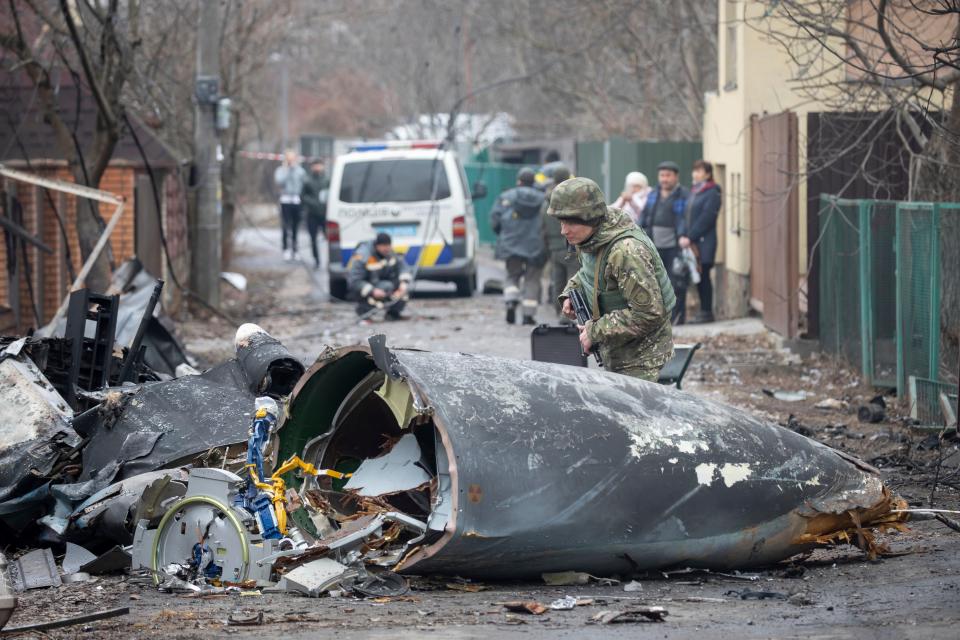 A Ukrainian Army soldier inspects fragments of a downed aircraft in Kyiv, Ukraine, Friday. It was unclear what aircraft crashed and what brought it down amid the Russian invasion in Ukraine.