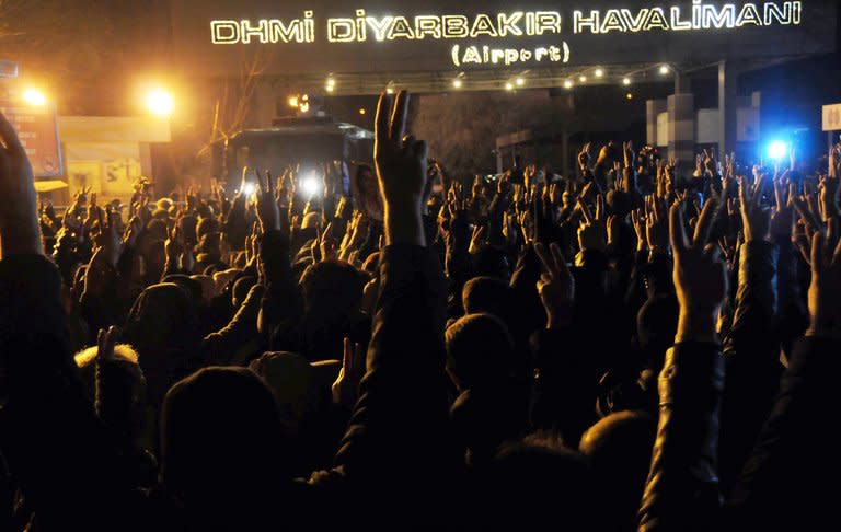 Thousands of people chant slogans outside the Diyarbakir airport on January 16, 2013 to welcome the coffins of the three female Kurdish activists who were killed in Paris last week. Several thousand Kurds gathered Thursday in a square in Diyarbakir, the main city of Turkey's Kurd-majority southeast, to pay a final tribute to the three