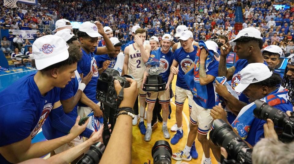 Kansas players celebrate with the Big 12 championship trophy after their 70-63 overtime win over Texas at Allen Fieldhouse on Saturday in Lawrence, Kan. The win gave the sixth-ranked Jayhawks a share of the conference title with Baylor.