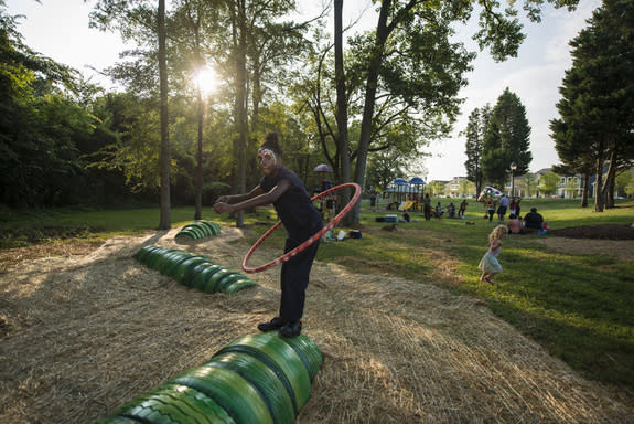 A visitor enjoys McColl Center environmental artist-in-residence Ruganzu Bruno's Playscape at its dedication in Brightwalk.