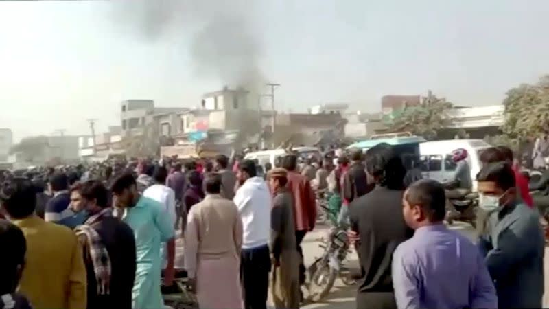 People gather after an attack on a factory in Sialkot