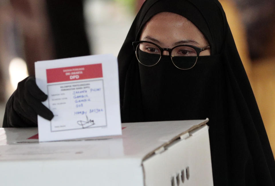 A Muslim woman casts her ballot during the election at a polling station in Jakarta, Indonesia, Wednesday, April 17, 2019. Voting is underway in Indonesia's presidential and legislative elections after a campaign that that pitted the moderate incumbent against an ultra-nationalist former general. (AP Photo/Dita Alangkara)