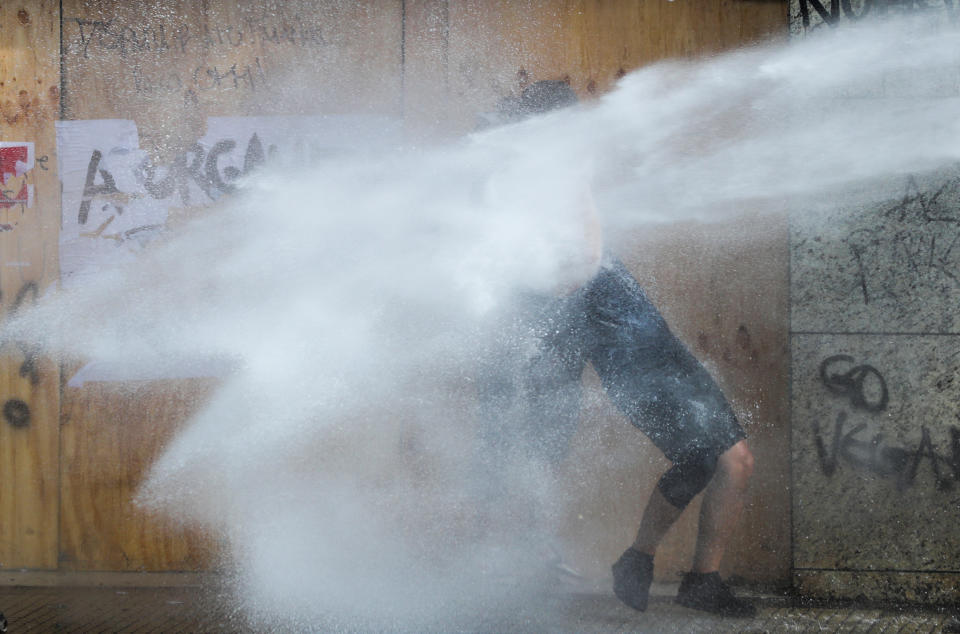 A demonstrator is sprayed by security forces with a water cannon during a protest against Chile's state economic model in Santiago, Chile on Oct. 23, 2019. (Photo: Ivan Alvarado/Reuters)